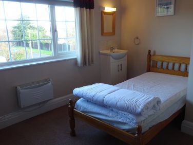 Triple room showing single bed and vanity unit.