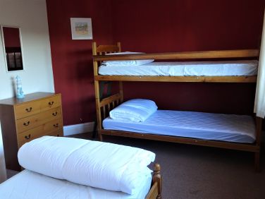 Triple room with single bed and bunk beds.