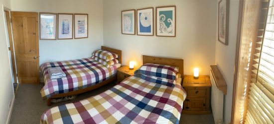 Bedroom 2 set up as two full width single beds, view down to the town and sea
