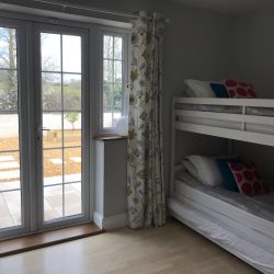 Bedroom 3 (sleeping 4)with bunks and double bed, doors to garden