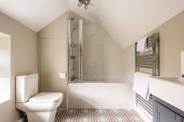The spacious bathroom offers a relaxing space to unwind, with full-sized bath & thermostatic shower