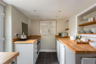 The refurbished kitchen boasts oak worktops with an induction hob and electric fan oven