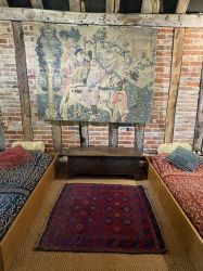Sleep in single Tudor style 'box beds' with tapestries on the wall