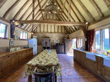 A large, sunny, well-equipped kitchen with dishwashers, big cooker, kitchen table to seat 14+