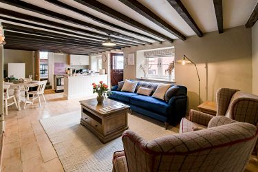 Cosy but spacious living area with exposed beams, wood flooring and ample seating