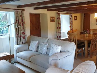 Laloma's sitting room focuses around the log burner with a comfortable sofa and chairs