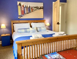 Horseshoe King size bed in master bedroom with windows looking  West, sunny afternoon/evening room.