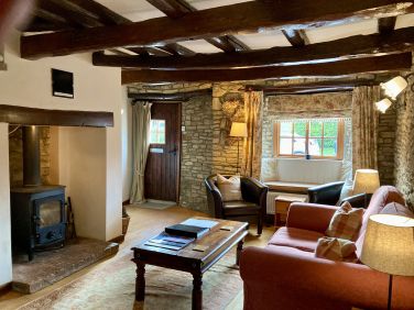 Ruth&rsquo;s Cottage has a cosy sitting room with beams and log burner