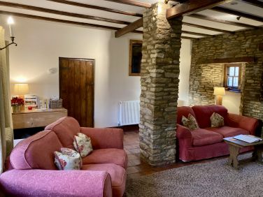 Bakers Cottage sitting room with beams and stone walls