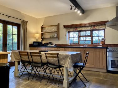 Ruth&rsquo;s Cottage kitchen with dining area and French doors leading out to the garden