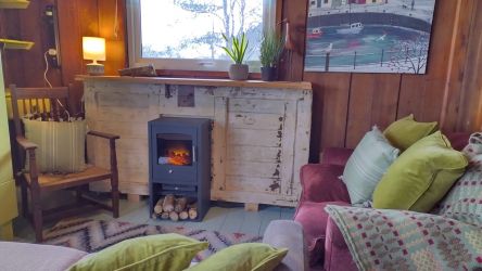 Cosy seating area with 2 sofas, electric log burner and TV (for films)