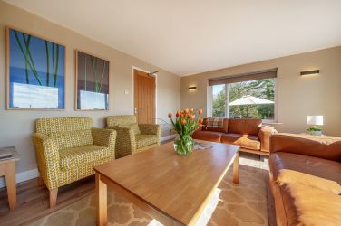 Orrest Head Cottage lounge with chairs and squishy leather sofas.