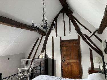 Family bedroom with exposed timbers and 'cruck frame'.