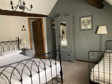 Family room with a king size and single bed.