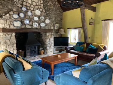 Spacious, comfortable lounge with seating around the log burner.