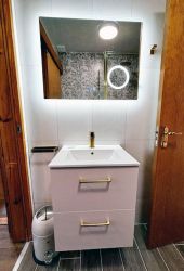 Hung basin with storage, illuminated, heated vanity mirror and bluetooth speaker.