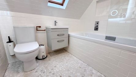 Family bathroom with bath and overhead shower.