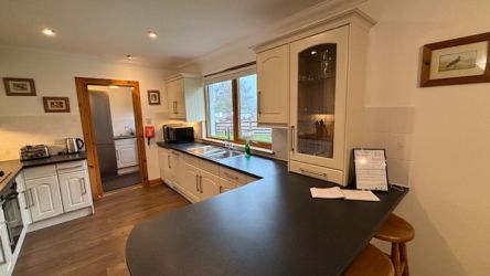A large breakfast with stools separates the kitchen and dining area.