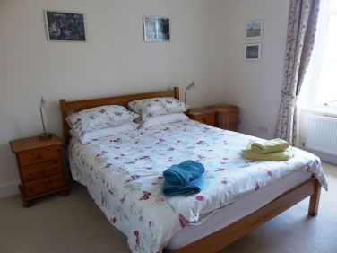 Large bedroom has kingsize bed, luxury guest bed and cot