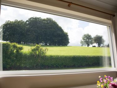 Wall & Lakes cottage, Brampton, relaxing by the living room window with peaceful countryside views