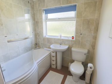 Sparkling clean, beautifully tiled bathroom with over the bath shower.