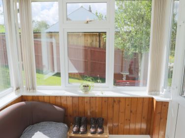 Walking boots rest in sunny porch Hadrian's Wall Talkin Tarn The Lakes; Pennine Way, Gelt Woods.
