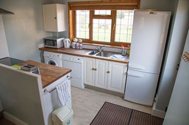 A fully fitted kitchen with microwave, oven tumble dryer and washing machine.