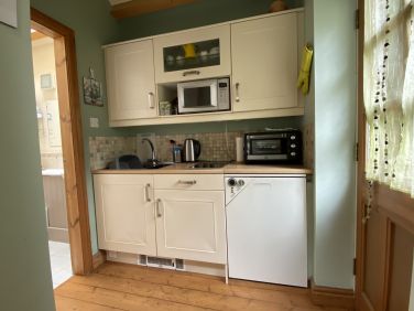 Kitchen with micro wave, mini oven and grill and electric hob.