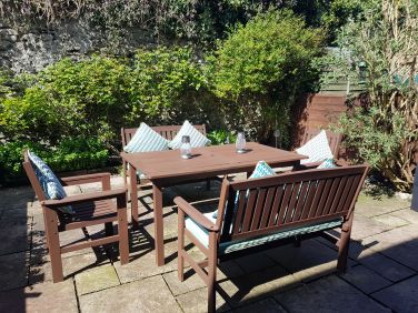 Rear enclosed paved garden with wooden garden furniture
