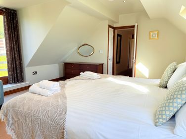 Comfortable bedroom with soft linens and a calm countryside feel