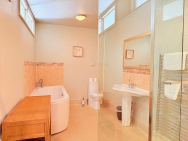 Clean, practical bathroom with bath and separate shower