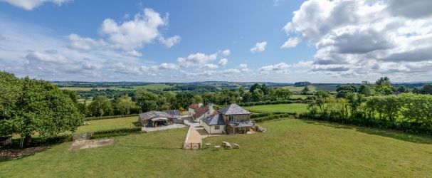 Aerial view of The Old barn, Higher Kellacott, with surrounded by fields and panoramic views