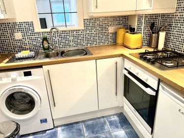 Kitchen equipped with washing machine and laundry drying racks