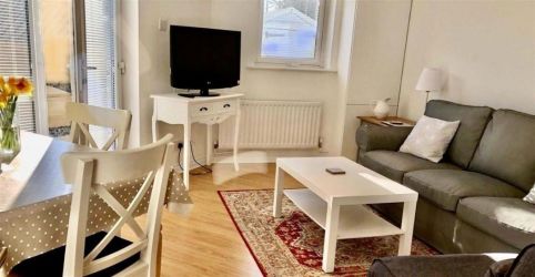 Lounge with comfortable sofa and dining table and chairs leading out onto large sunny private terrac