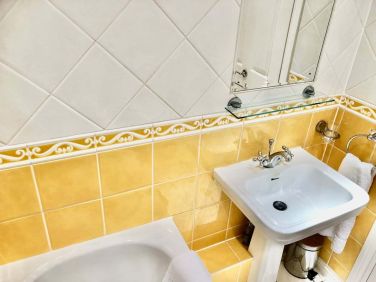 Separate bathroom with shower over bath. Towels provided