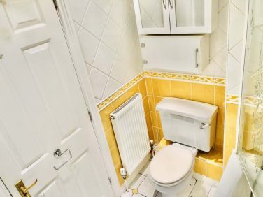 Full size toilet with cabinets above