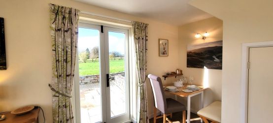 Sunny sitting room with spacious seating area and separate dining alcove.