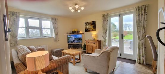 Sunny sitting room with electric feature fire and smart TV. Separate dining area