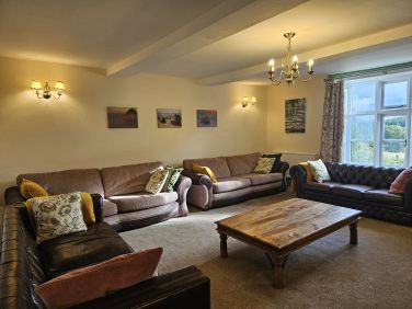 The lounge has 4 large sofas and french windows overlooking the garden