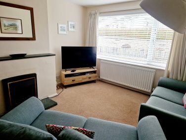 Cosy lounge with large Tv and electric fire place.