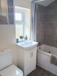 Full bathroom with Jacuzzi bath and shower over bath.