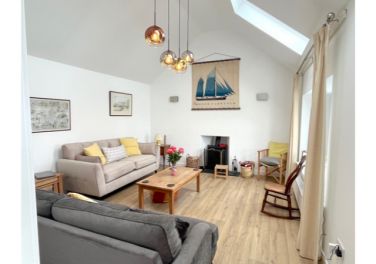 Bright living room with vaulted ceiling and sea views