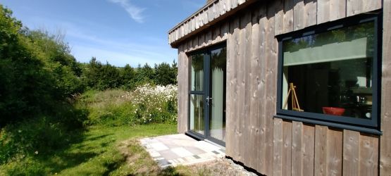Side of the house with fields at the back.