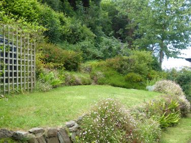 Rear garden with coast path behind beech hedge
