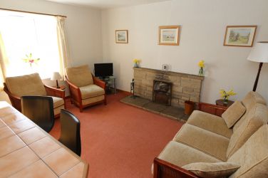 Cosy living room and open plan kitchen, with breakfast bar.