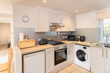 Well-equipped kitchen with fridge (small freezer), microwave, oven, hob, toaster, and washer/dryer