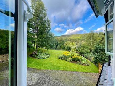 The double bedroom window offers a picturesque view of the surrounding Highland landscape.
