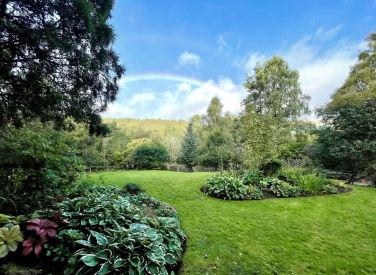 The cottage has a lush, fully enclosed garden with seating for watching the world drift past