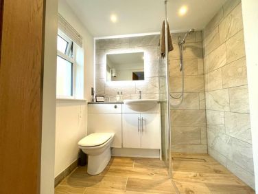 The walk-in wet room features a heated towel rail, heated mirror, and luxury underfloor heating.