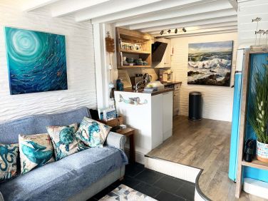 Open plan living room and kitchen, with beautiful painting by award winning artist Wendy Darker.